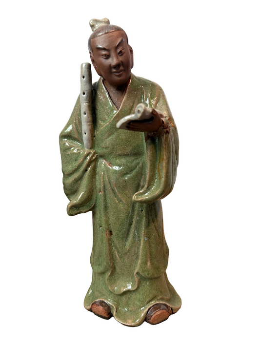 Green ceramic figurine of a person holding a scroll 